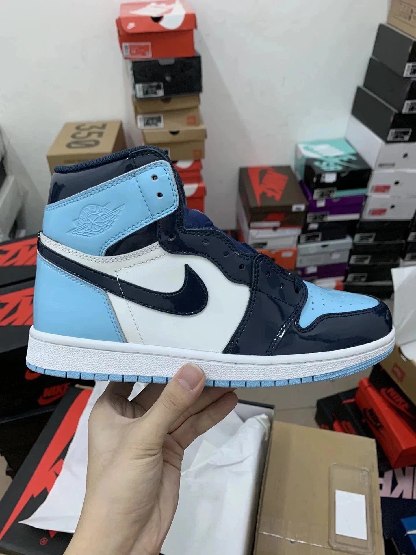 Small-waist, hourglass silhouette; long-term, stable supply. Air Jordan 1 Retro “North Carolina” patent leather—#Prime Asia, genuine Napa leather with matching reflective finish. Featuring 3D Fly-Wing high-frequency detailing and full-coverage rubber print, with a built-in Sool air cushion.