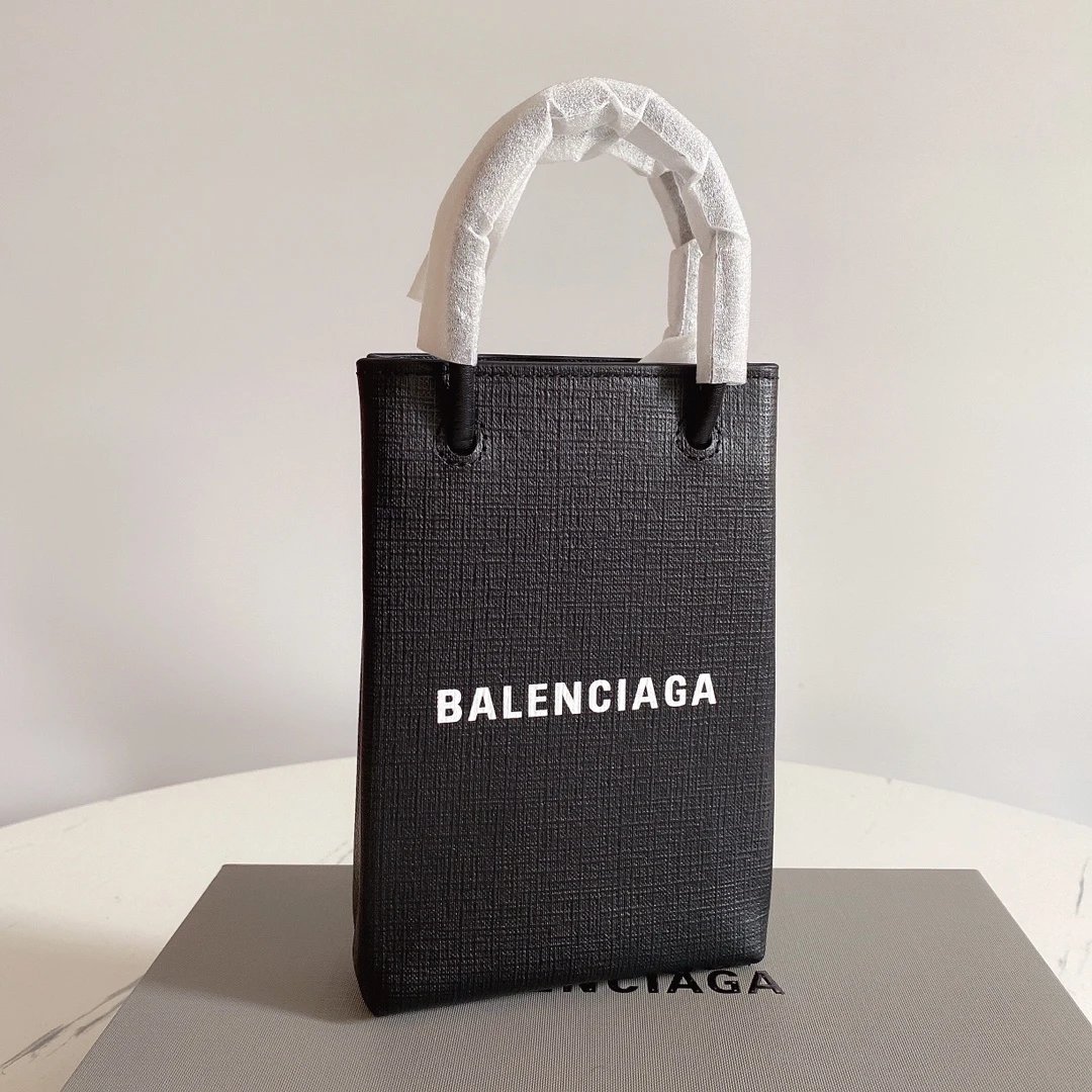 现货【名品之家】巴黎世家原单B家BALENCIAGA黑色Balenciagα牛皮购物袋新成员——手机包 想要帅、简洁又不用担心出错的话，万能购物袋绝对是没毛病的呀 作为家中最袖珍的一员，它等我大小恰到好处，可以轻松放...